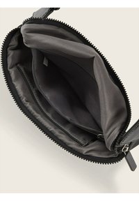 Zwarte ritszak met een gladde buitenkant, voorzien van een gevoerde binnenkant met één ritsvak en een hoofdcompartiment. Geëmbosseerde ritsdetails.