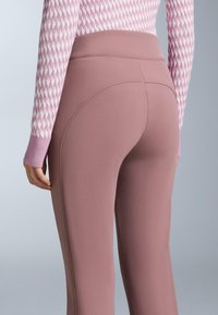 Užežnute ružičaste tajice od glatkog tkanja, s visokim pojasom i suptilnim detaljima šavova radi dodatnog oblika i udobnosti.