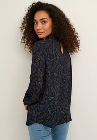 Námornícka blúzka s paisley vzorom v bronzových tónoch, dlhé rukávy a detail s otvorom na chrbte. Ľahká látka s voľným strihom.