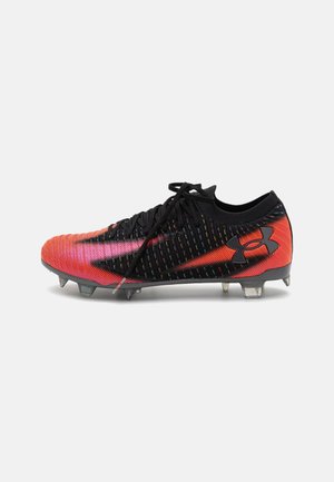 Scarpini da calcio neri e rossi con una tomaia texture, caratterizzati da un design sfumato, chiusura con lacci e tacchetti trasparenti per una migliore trazione.
