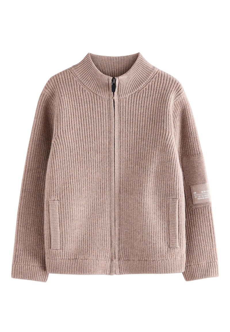 Cardigan beige doux et côtelé avec col montant, fermeture éclair, poches latérales et étiquette en tissu sur la manche gauche.
