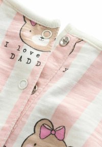 Tissu à rayures roses et blanches avec un graphique de dessin animé d'ours et le texte « J'aime PAPA. » Dispose de fermetures à pression au niveau du col et d'une texture douce.