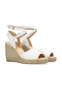 Witte leren wedge sandaal met open tenen, met kruislings enkelbandjes en een geweven jute hak, gestructureerd voor grip.