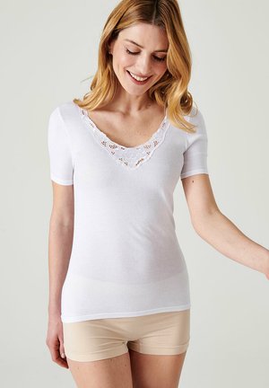 Top blanco de manga corta con un escote en V profundo y detalles de encaje. Presenta una tela suave y ligera y un diseño ajustado.