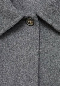 Manteau en laine gris avec un col classique, un devant plat et une fermeture à un bouton, doté d'une finition douce et texturée.