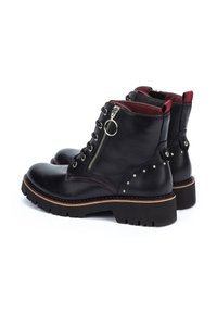 Black leather ankle boots with a round toe, featuring a side zipper, red interior, stud accents, and a textured black rubber sole.