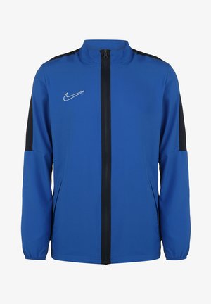 Blaue Nike-Jacke mit durchgehendem Reißverschluss, hohem Kragen und schwarzen Akzenten an den Schultern. Hergestellt aus leichtem, glattem Material.