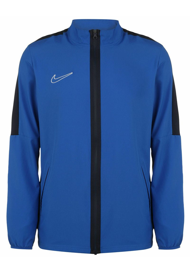 Blauwe Nike-jas met een volledige ritssluiting aan de voorkant, hoge kraag en zwarte accenten op de schouders. Gemaakt van lichtgewicht, soepel materiaal.