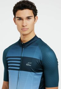 Jersey de ciclismo de manga corta en tonos azules, con cierre de cremallera, patrón geométrico y un logo en el pecho. Ajuste atlético suave.