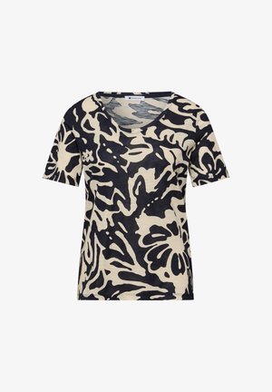 Camisa beige de manga corta con grandes patrones abstractos de flores y hojas en negro, escote redondo, ajuste casual.