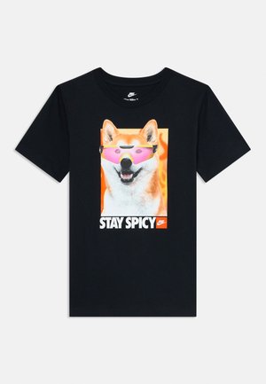 T-shirt noir avec un chien Shiba Inu portant des lunettes de soleil roses et le texte "STAY SPICY" sous l'image avec un petit logo Nike.