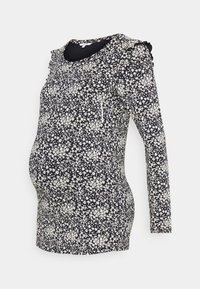 Kojenecký top s dlouhým rukávem v námořnické modři s bílým květinovým vzorem, s volány na ramenou a přiléhavým střihem, aby vyhovoval rostoucímu bříšku.