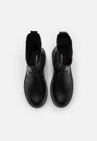 Botas negras hasta el tobillo con parte superior de cuero liso, paneles laterales elásticos y puntera redonda. Presentan una suela de goma plana y un forro interior suave.