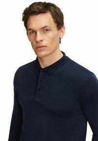 Navyblaue Langarm-Polohemd aus glattem Stoff, mit Kragen und Dreiknopf-Leiste, mit enganliegendem Schnitt.