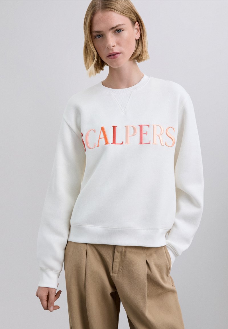 Vit sweatshirt i mjukt tyg med en stor, gradient broderad text "SCALPERS" i nyanser av orange. Avslappnad passform med ribbade muddar.