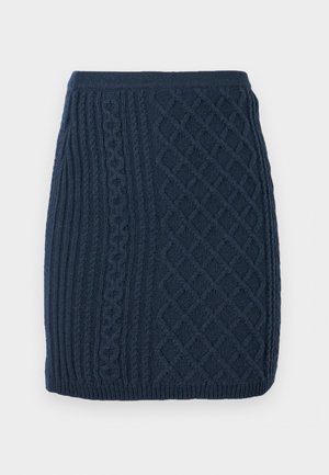 Mini-jupe tricotée bleu marine avec des motifs en côtes et en torsades, présentant une finition texturée et une taille ajustée.