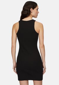 Robes tank côtelées noires avec une coupe ajustée, un design sans manches et un col rond; texture douce visible dans le tissu.