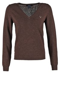 Pull marron à col en V en tissu tricoté texturé. Il comporte des manches longues, des poignets côtelés et un petit logo sur la poitrine.
