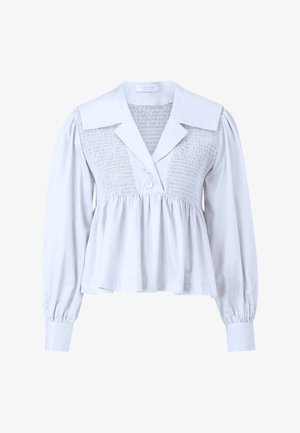 Blusa bianca con scollatura arricciata, colletto oversize e maniche lunghe a sbuffo con polsini con bottoni. Orlo svasato per una vestibilità comoda.