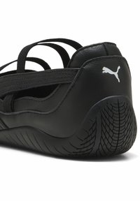 Sort atletiksko med et strømlinet design, der har en tekstureret gummisål og elastiske stropper for en sikker pasform. Puma-logoet på hælen.