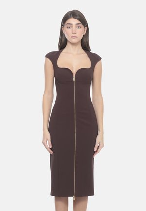 Donna che indossa un abito midi aderente marrone scuro con maniche a campana e una cerniera frontale che si estende dal collo all'orlo.