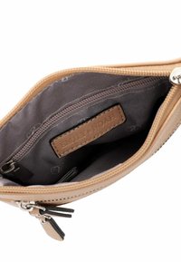 Interno di un portafoglio in pelle tan con foderatura grigio scuro, una tasca con zip e un'etichetta in pelle brandizzata con il nome "Emily Noah".