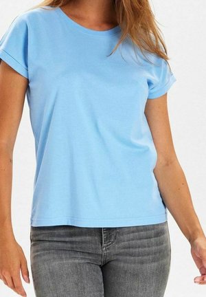 Hellblaues Baumwoll-T-Shirt mit Rundhalsausschnitt und umgeschlagenen kurzen Ärmeln. Glatte Textur, lässige Passform, kombiniert mit grauen Jeans.