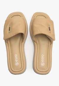 Tan instappers gemaakt van glad synthetisch materiaal, met een gevoerde band en een afgerond teenontwerp. Logo-accent zichtbaar op de band.