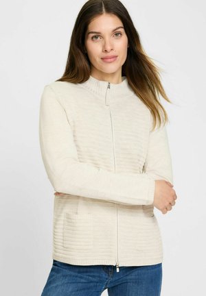 Lichtbeige ritsjack met gestructureerde strepen en geribde manchetten, met twee zijzakken en een hoge kraag.