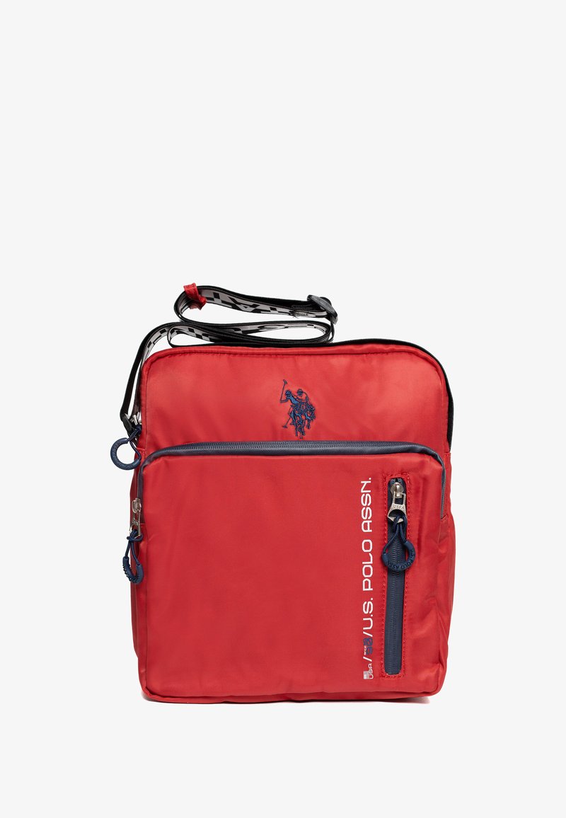 Červená kabelka přes rameno s kapsami na zip v námořnické modři, logem U.S. Polo Assn. a nastavitelným popruhem s černo-bílým vzorem.