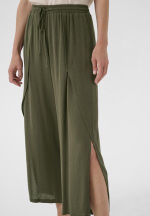 Pantalons larges couleur olive, légers, avec une taille à cordon, présentant des fentes latérales pour la ventilation et un tissu doux et texturé.