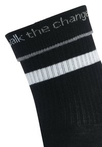 Calzino nero con strisce bianche alla caviglia. Testo "walk this change" in grigio nella parte superiore. Texture liscia, materiale elastico.
