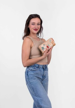 Tan floral-embossed wallet with a zipper, featuring multi-colored embroidered flowers on a beige background, held in a person's hands.