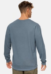 Langärmliges Shirt aus strukturiertem, hellblauen Stoff mit Rundhalsausschnitt und gerippten Bündchen. Lässige Passform mit einem schlichten, minimalistischen Design.