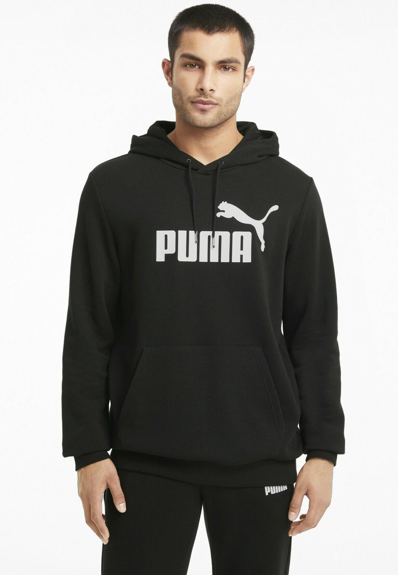 Hoodie noir en mélange de coton, avec un grand logo Puma blanc à l'avant et une poche kangourou. Manches longues avec des poignets côtel�és.