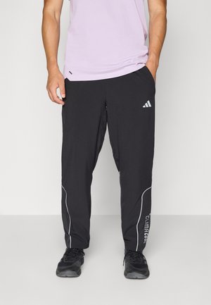 Black athletic pants with light gray accent lines and "ClimaCool" text. Features a loose fit, elastic waistband, and side pockets.