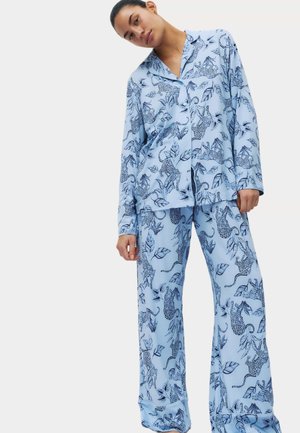 Lichtblauw pyjamaset met blad- en luipaardpatronen. Gemaakt van zachte stof; bestaat uit een overhemd met knopen en wijde broekspijpen.