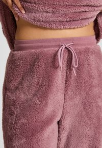 Zachte, fluffy roze loungewear broek met een elastische tailleband en koord. Heeft een gestructureerde, pluche stofafwerking.