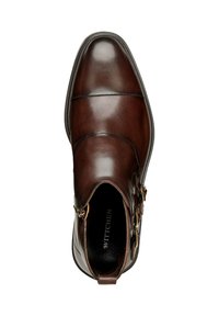 Zapato de cuero marrón con un diseño elegante, que cuenta con dos hebillas laterales y detalles de costura. Superficie lisa y pulida con punta redondeada.