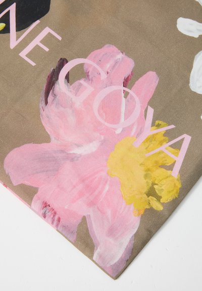 Blommönstrad tyg med rosa, gula och vita blommor på en brun bakgrund med ordet "GOYA" i ljusrosa. Mjuk textur.