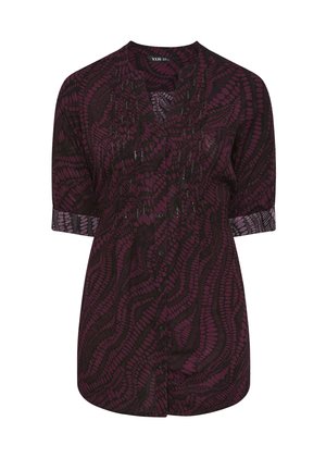 Lila und schwarze gemusterte Bluse mit kurzen Ärmeln, Knopfleiste und strukturiertem Stoff, der wirbelnde Designs und subtile Akzente aufweist.