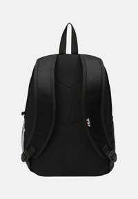 Svart ryggsäck tillverkad av slitstarkt tyg med ett chevronmönster på baksidan. Har vadderade axelremmar, ett handtag på toppen och nätfickor på sidorna.