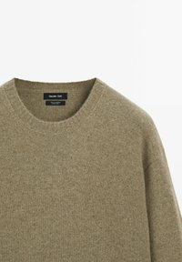 Olijfgroen ronde hals cashmere trui met geribbelde kraag van Massimo Dutti, weergegeven op een witte achtergrond.