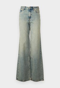 Jean large bleu clair en denim, avec taille haute, délavage, et poches latérales avec surpiqûres visibles.