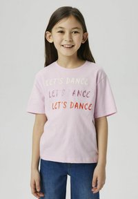 Camiseta de algodón rosa con mangas cortas que presenta un texto multicolor "¡BAILEMOS!" en diferentes tipografías, combinada con jeans azul oscuro.