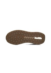 Bruine rubberen schoenzool met een honingraatpatroon voor grip. Voorzien van witte logo-accenten en een gladde textuur rond de randen.