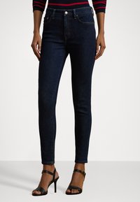 Dark blue skinny jeans with a smooth denim texture, featuring a classic five-pocket design and a fitted silhouette.