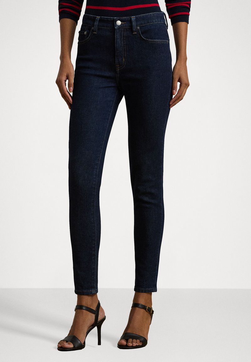 Dark blue skinny jeans with a smooth denim texture, featuring a classic five-pocket design and a fitted silhouette.