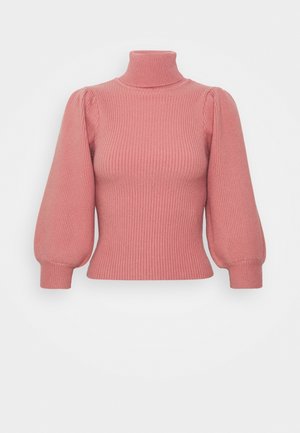 Pull rose à col roulé en maille côtelée avec manches longues bouffantes et poignets ajustés sur un fond uni.