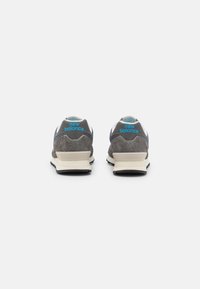 Scarpe sportive in suede grigio e mesh con accenti blu, dotate di suola ammortizzata e un logo prominente sul retro. Vista posteriore.